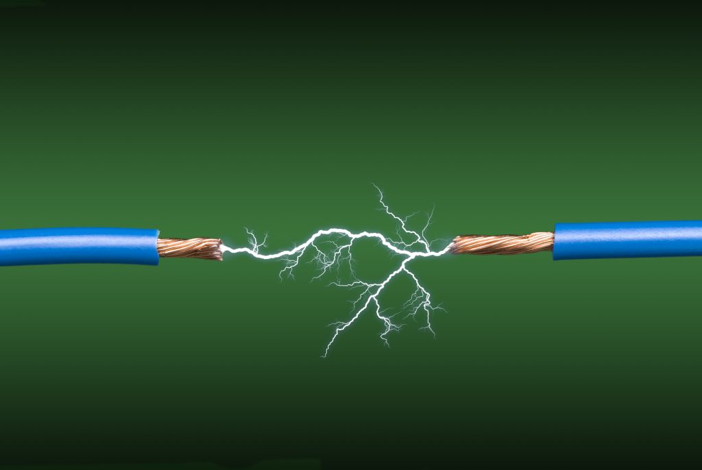 An electrical arc crossing two blue, copper wires on a green and black gradient background.